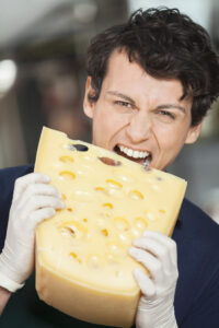 homme dégustant un gros morceau de gruyère chez un fromager lyonnais